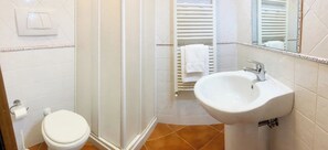 A bathroom with a toilet, a shower enclosure, and a sink. - panoramica casa con piscina privata (siena)