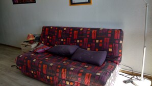 A room with a patterned sofa, a lamp, a framed picture, and a floor lamp. - Apartment facing south, magnificent views, secure private garage (Font-Romeu-Odeillo-Via)