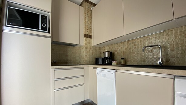 A compact kitchen with a microwave, coffee maker, and dishwasher. - Top-floor apartment with amazing sea view (Menton)