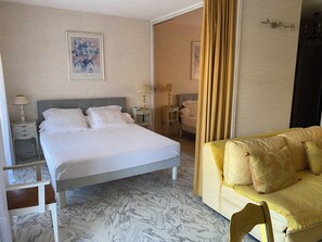 Ein Hotelzimmer mit einem Bett, Nachttischen, einer Couch und einem Marmorboden.