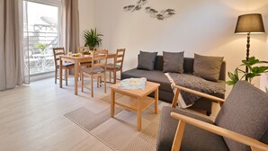 Un salon moderne comprenant un canapé, un fauteuil, une table à manger et des chaises.
