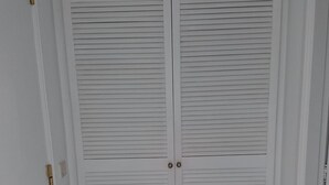 A closed white door with a decorative ceiling light fixture above it.