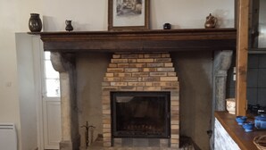 A room with a brick fireplace, a wooden mantel, and a framed picture above it.