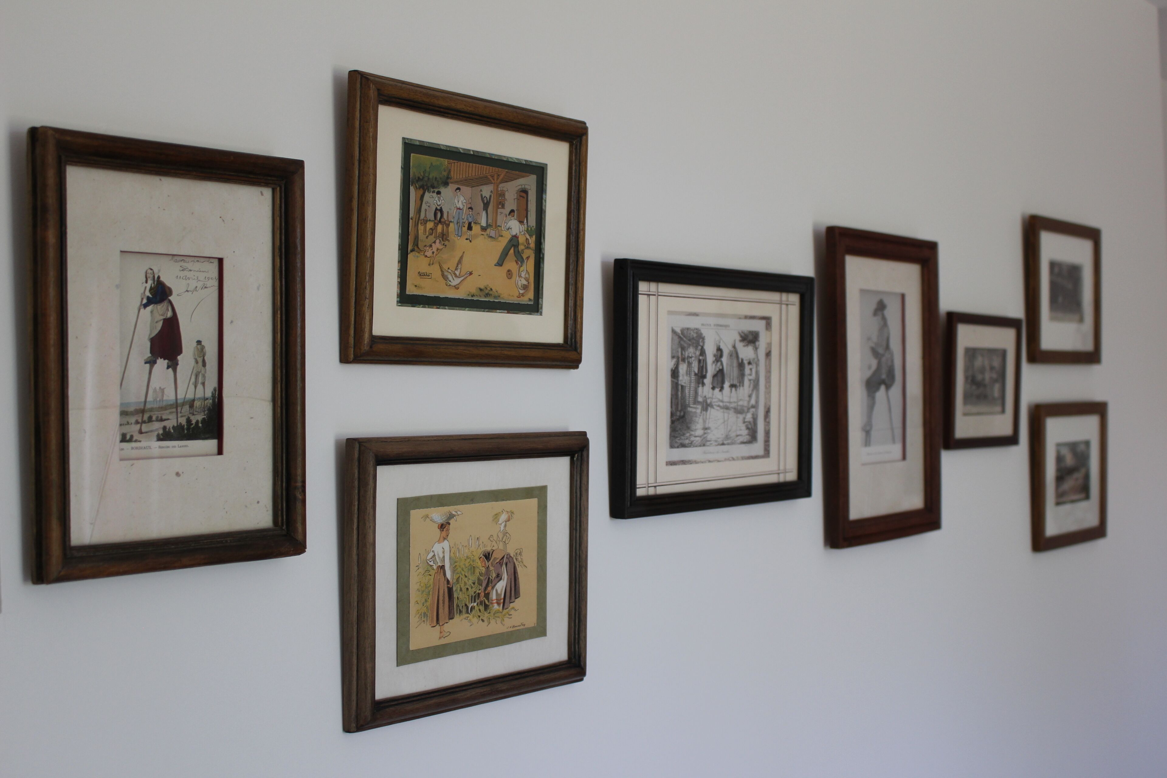 Un mur orné de plusieurs œuvres d’art encadrées.