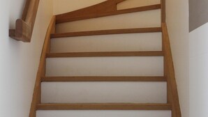 Una escalera de madera con barandilla y un rellano.