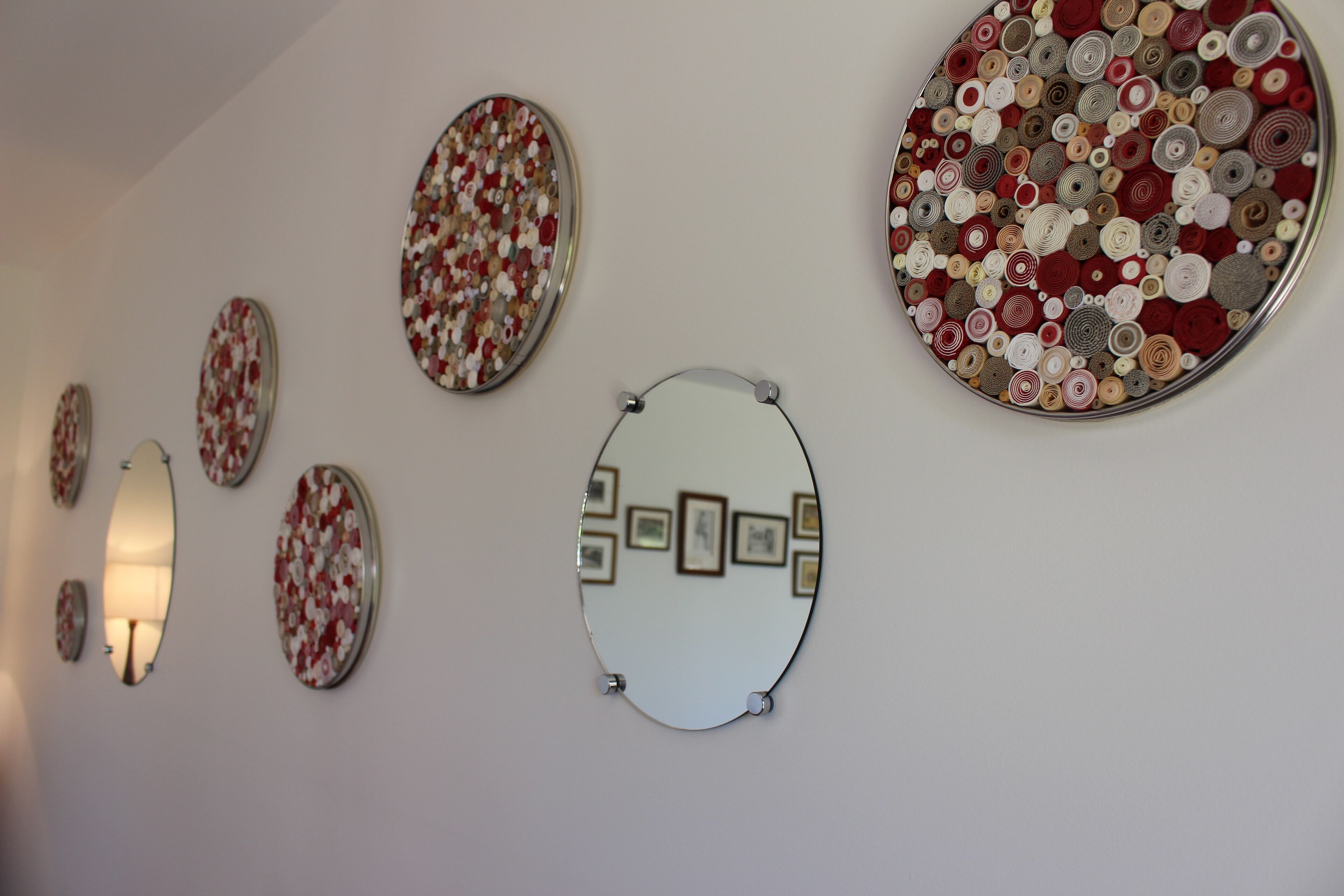 A wall with various circular mirrors and decorative plates.
