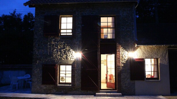 Un edificio de piedra con varias ventanas y puertas, algunas iluminadas por la luz.