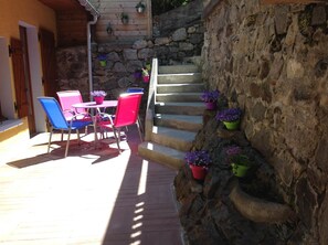 A patio with outdoor furniture, a stone staircase, and potted plants.
