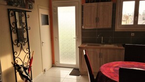 Een keuken met houten kastjes, een spoelbak en een raam.