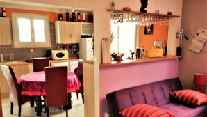 Een ruimtelijke leefruimte met een eethoek, kitchenette en een slaapbank.