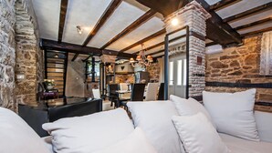 A cozy room with stone walls, a wooden ceiling, and a comfortable seating area with white cushions. - Stylish Istrian Retreat with Pool, Tennis Court & Outdoor Kitchen (Pican)