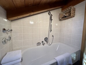 Banheira, secador de cabelo, toalhas de banho, papel higiênico