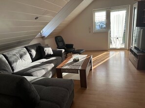 Een moderne woonkamer met een bank, een salontafel en een televisie.