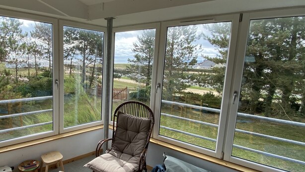 A room with large windows offering a view of a grassy area and trees.