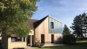 A modern two-story house with a wooden facade and a sloped roof.