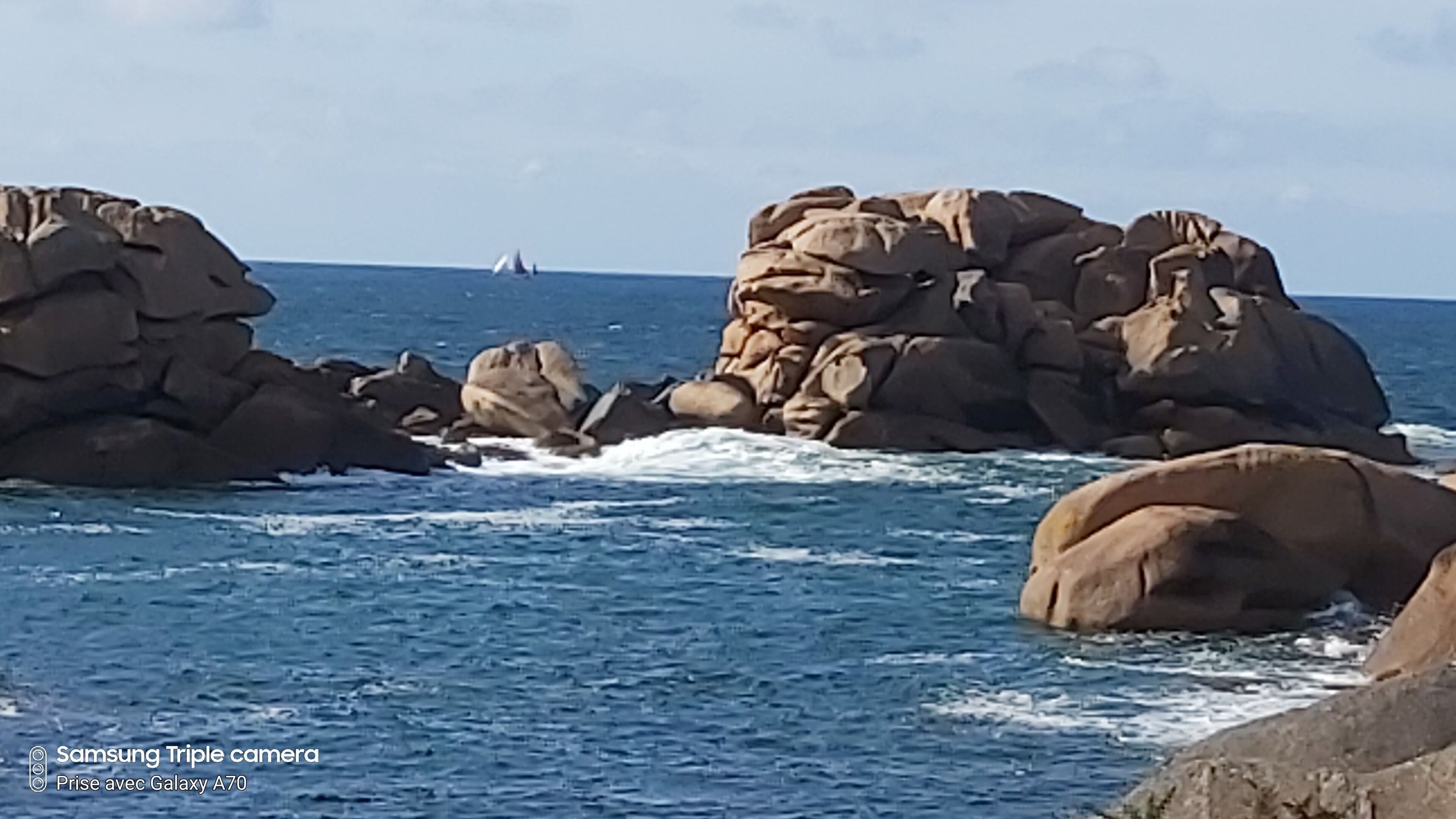 Línia costanera rocosa amb onades que es trenquen contra les roques.