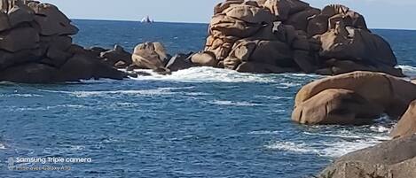 Línia costanera rocosa amb onades que es trenquen contra les roques.