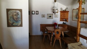 A dining area with wooden furniture, a chandelier, and wall-mounted artwork.