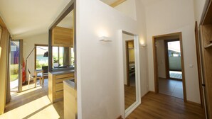 Une cuisine moderne avec des meubles en bois, un coin repas comprenant une table et des chaises, et une vue sur l’extérieur grâce à une porte vitrée.