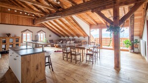 Un comedor amplio con mesas y sillas de madera, una isla de cocina y vistas al exterior.