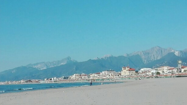 A beach with buildings and mountains in the background. - Rustico in a panoramic position, terrace with sea view. (Pietrasanta)