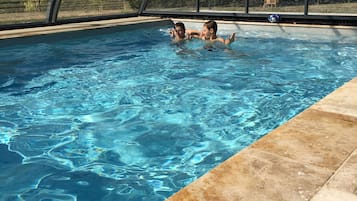 Een buitenzwembad en een verwarmd zwembad