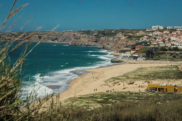 Une ville côtière avec une plage, des falaises et des bâtiments.