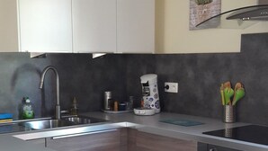 Een moderne keuken met een centraal kookeiland, roestvrijstalen apparatuur en een vaatwasser.