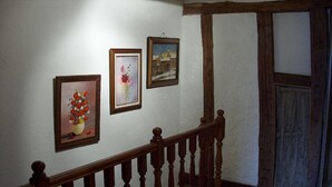 A staircase with wooden balusters and a handrail, leading to a room with a wooden door and a window.