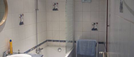 A bathroom with a bathtub, a sink, and a shower.