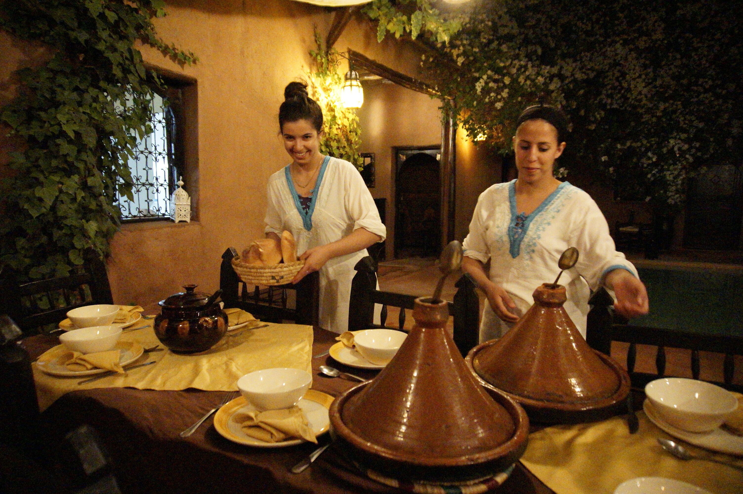 A dining area with a table set for a meal, including a pot, bowls, and a traditional clay pot.