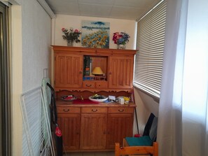 Cozy retreat with a wooden cabinet, chair, and wall art, perfect for relaxation.