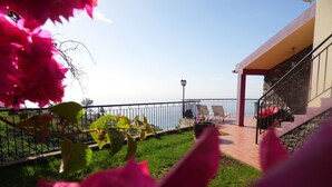 A balcony with a view of the sea, a stone wall, and a railing. - sea view everywhere in the house (Estreito da Calheta)