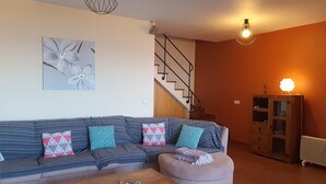 A living room with a sofa, ottoman, coffee table, and a staircase. - sea view everywhere in the house (Estreito da Calheta)