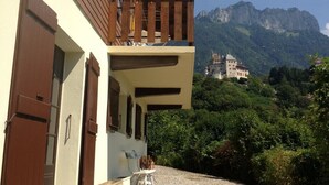 Un edificio con balcón que da a un paisaje montañoso.