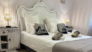 A neatly arranged bedroom with a large bed, two bedside tables, and a nightstand. - Charming house with heated swimming pool, in a quiet, unoverlooked location. (Saint-Rémy-De-Provence)