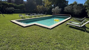 A rectangular swimming pool with a wooden deck, surrounded by a well-maintained lawn and trees. - Charming house with heated swimming pool, in a quiet, unoverlooked location. (Saint-Rémy-De-Provence)