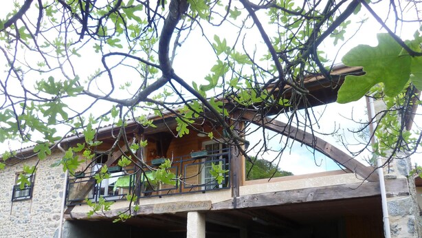 A stone building with a balcony and a covered area.