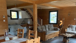 Een houten interieur met een eethoek, bank en keuken.