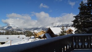 Paisaje nevado con cabañas de madera y una montaña al fondo.