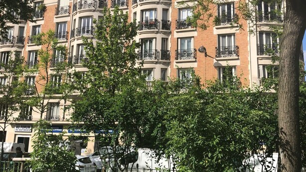 A multi-story residential building with balconies, a brick facade, and a clear blue sky. - like  a presidential suite with a magnificient view (Paris)