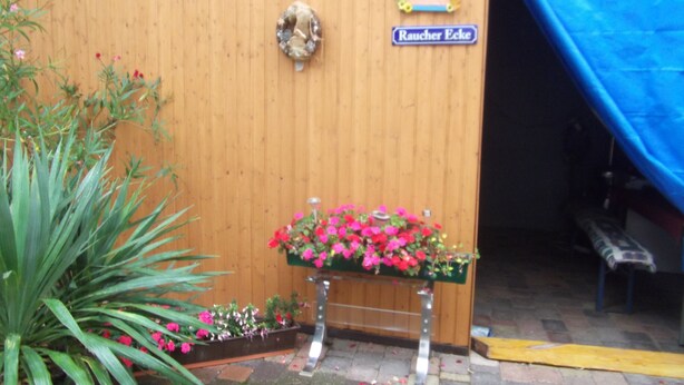 Een houten deur met een bord waarop staat 'Raucher Ecke'.