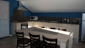 Une cuisine moderne dotée d’un îlot central, d’un four à micro-ondes encastré et d’une cuisinière.