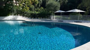 A clear blue swimming pool with a tiled deck, surrounded by a white fence and trees. - CANNES low  California LUXURY T2 65M2, SWIMMING POOL, PARKING NEAR CROISETT (Cannes)