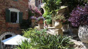 A courtyard with stone walls, potted plants, and a sign that reads "ART ET CURIOSITÉS". - CANNES low  California LUXURY T2 65M2, SWIMMING POOL, PARKING NEAR CROISETT (Cannes)
