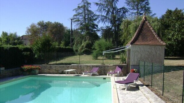 A swimming pool with clear water, surrounded by stone tiles and a wooden gazebo. - Charming 70m2 villa with private pool (Castelnau D'auzan Labarrère)
