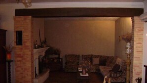 A cozy living room with a fireplace, comfortable seating, and a dining area. - Charming 70m2 villa with private pool (Castelnau D'auzan Labarrère)