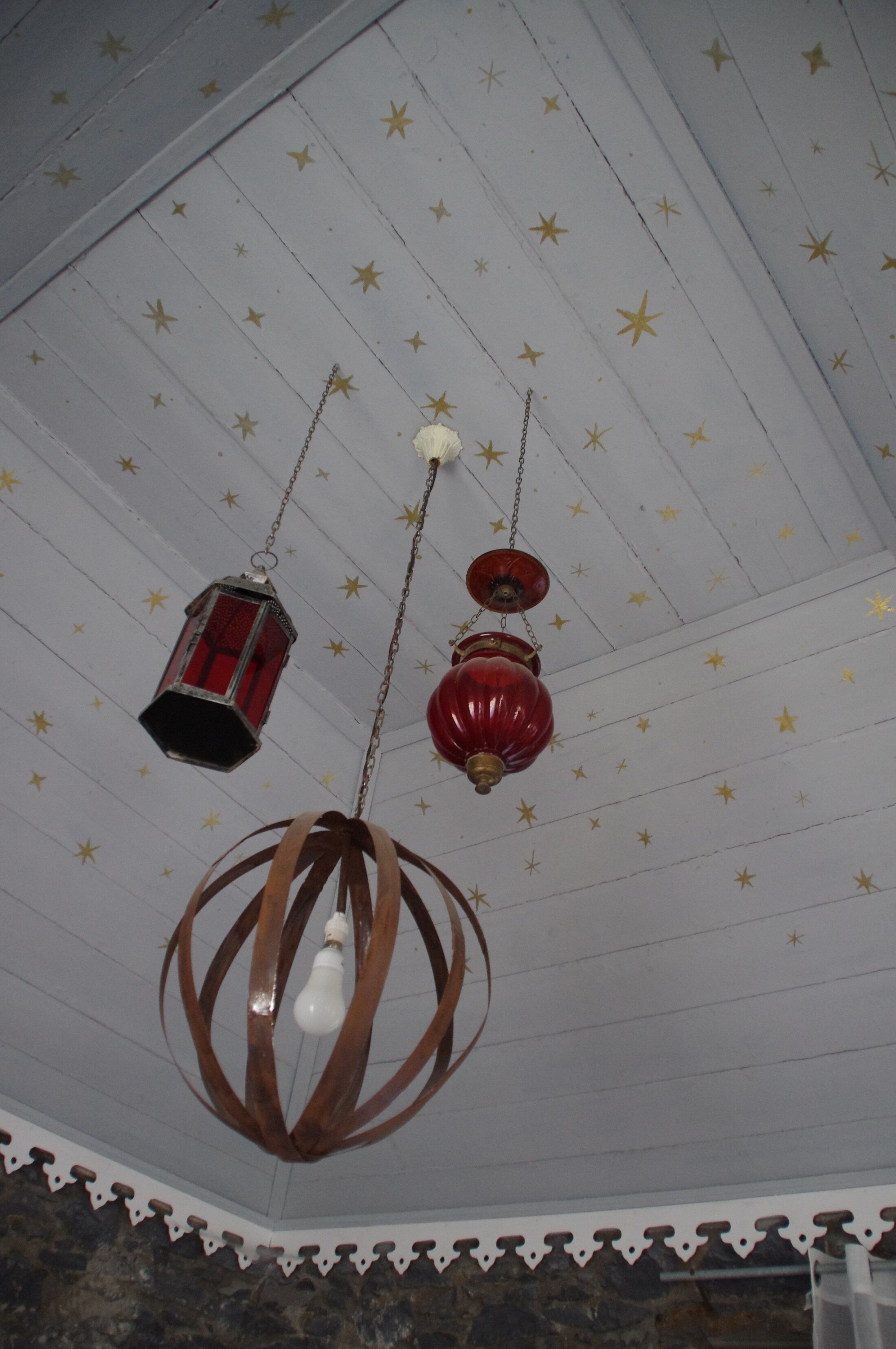 A ceiling with star patterns and hanging light fixtures.