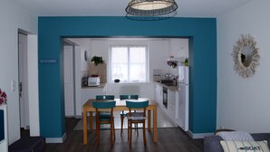 Una cocina moderna con comedor, un sofá y un cartel que dice 'Le Guilletemec'.