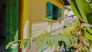 Un edificio amarillo con puerta y contraventanas verdes.